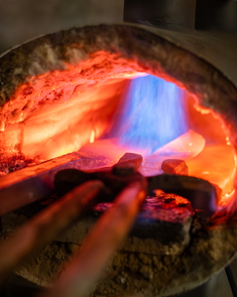 Barres d’acier chauffées au rouge dans le foyer de forge à la flamme, atelier Meignoz Forges & Lames à Romans-sur-Isère (Drôme)